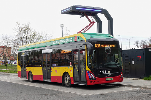 Lodz, Poland - 27th April, 2023: Electric bus Volvo 7900 Electric on a charging point on a bus loop. The electric buses replaces Diesel as fuel in public transport in future.