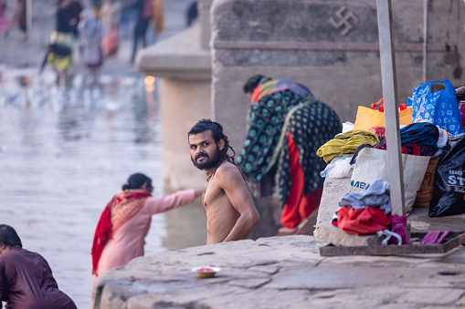 Varanasi, Uttar Pradesh, India - November 2022: Brahmin male taking holy dip in river ganges as hindu ritual during morning.
