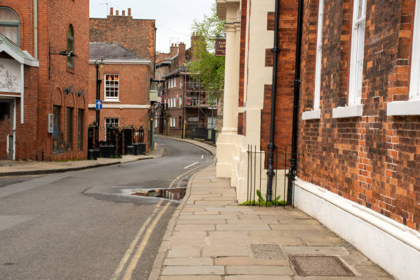 istock Narrow street lined with traditional British brick. 1498190380