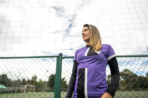 Soccer player mid adult woman contemplating on soccer field