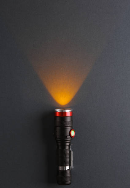 включен яркий фонарик на темном фоне - black flashlight light bulb electricity стоковые фото и изображения