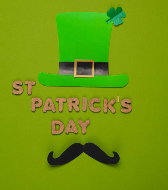 St patrick's day text with themed decor on green background. Flat lay
