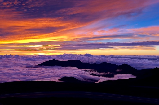 Breathtaking morning sunrise from the peak of Haleakala in Maui (Hawaii) with cloud layer and colorful sky