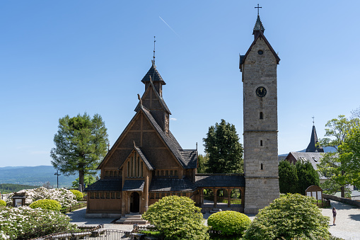 Karpacz, Lower Silesian Voivodeship, Poland - May 31, 2023: This captivating photograph showcases the Vang Stave Church, also known as the Mountain Church of Our Savior, located in Karpacz, Poland. Originally hailing from Vang in the Valdres region of Norway, this remarkable Stave church was dismantled and reconstructed in its current location in 1842. As the only stave church in Poland, it holds significant historical and cultural importance. Standing proudly amidst the scenic Karkonosze mountains, the church attracts numerous visitors as a notable tourist attraction. The image captures the grandeur and architectural beauty of this majestic church, surrounded by the natural splendor of the Polish mountains.