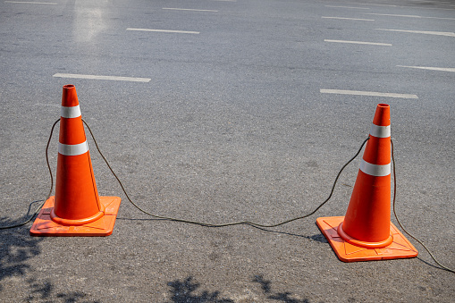 Two traffic cones with a rope in a street in the center of the Thai capital