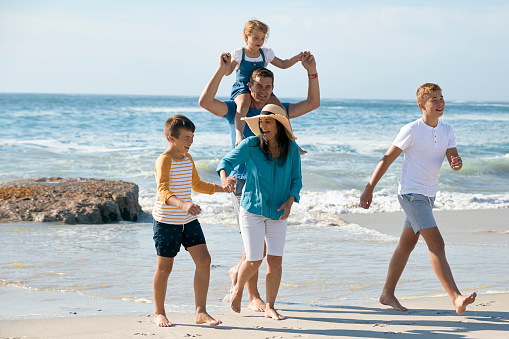 Shot of a family and their kids spending the day at the beach