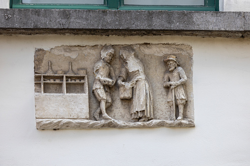 Ghent, Belgium - May 19, 2023: Relief of facade of tenement house next to Zuivelbrug bridge by Lys river (Leie)