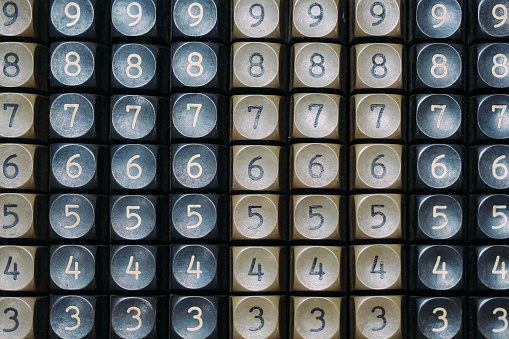 A solid background of numbers on the plastic buttons of an outdated calculator. Texture of numbers. Numerology and numbers. Abstract background.