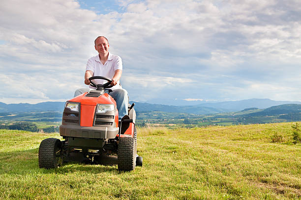 mann auf einem aufsitzmäher - lawn mower tractor gardening riding mower stock-fotos und bilder