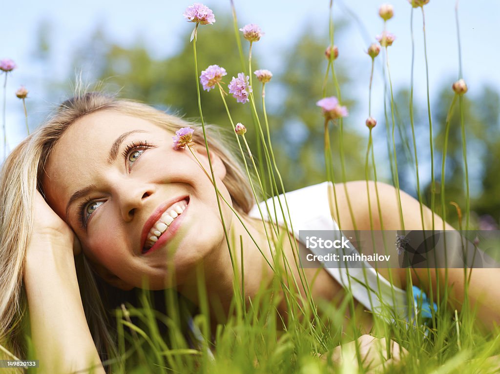 Girl in a grass (medium format image) Attractive girl dreaming in a grass with flowers Women Stock Photo
