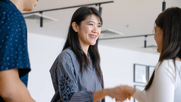 istock Asian female shaking hand with client during a meet up session in a cafe 1498201642