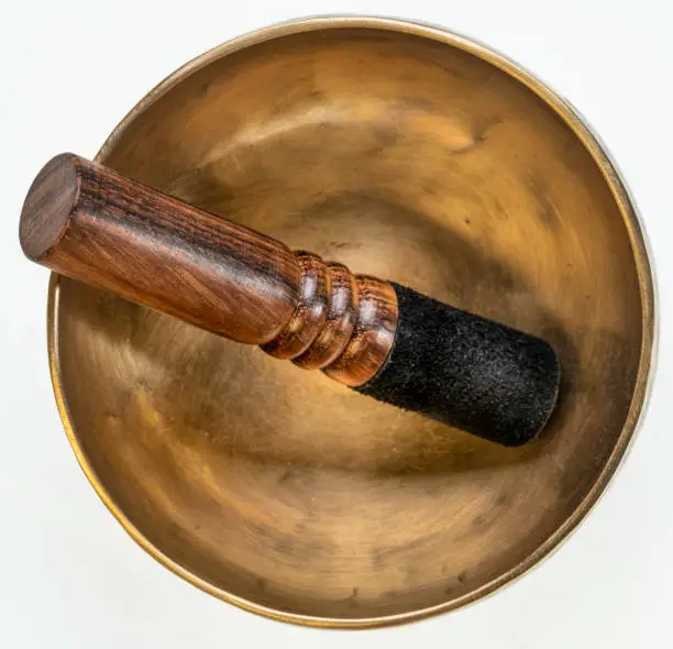 handmade tibetan singing bowl with a mallet isolated on white, sound therapy for healing, relaxation and meditation