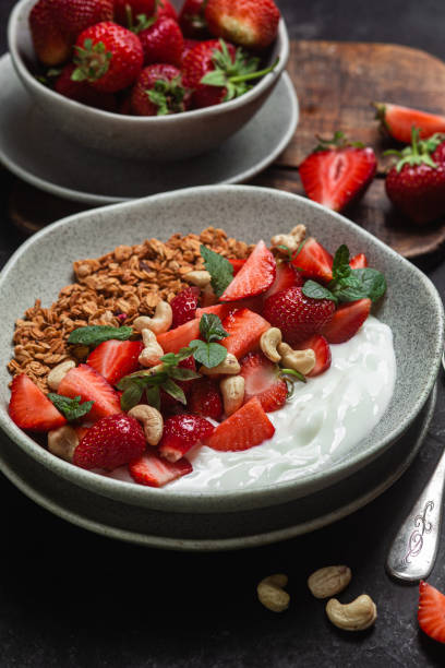 istock Granola with yogurt and strawberries in a plate on a dark background 1498203969