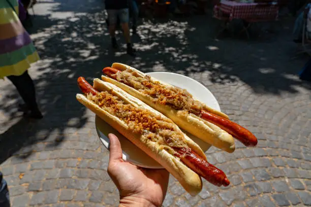 german bavarian hot dog in viktualienmarkt munich with sauerkraut street food .