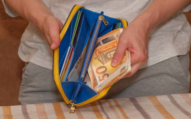 istock Women's hands open a wallet with 50 euro banknotes and plastic cards. 1498216624
