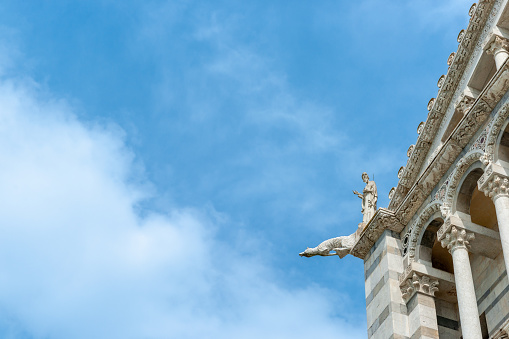 Gargoyle dog waterspout on top corner of medeival church in italy.1