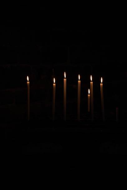 istock Dramatic image of numerous flickering candles illuminating a shadowy church interior 1498218179
