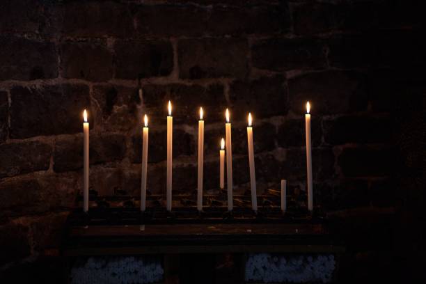 istock Dramatic image of numerous flickering candles illuminating a shadowy church interior 1498218186