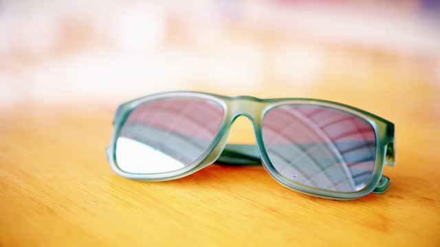 A sunglasses on wooden table.