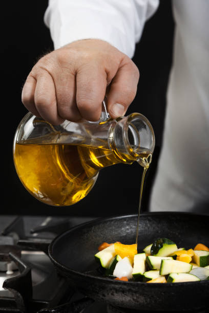 chef is pouring olive in frying pan