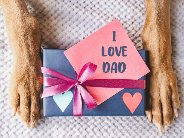 istock Dog paws, gift box and note for Father 1498220571