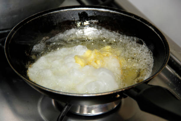 istock frying pan with fried egg and a lot of oil 1498221493