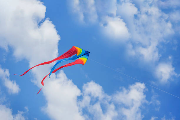 istock Colorful flying kite flying in sky with clouds 1498226083