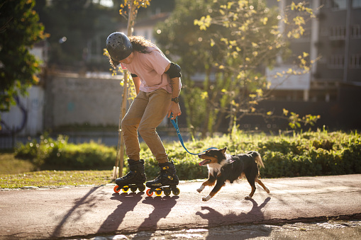 Man roller blading with his mixed-breed dog