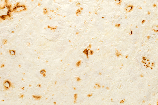 Pita tortilla, baked surface close-up, uniform texture background