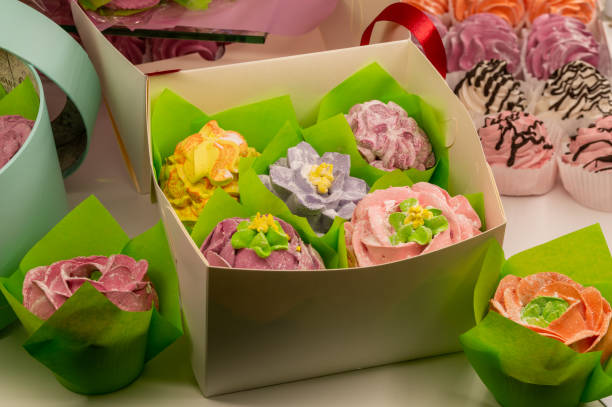 cupcakes decorated with cream in a paper box