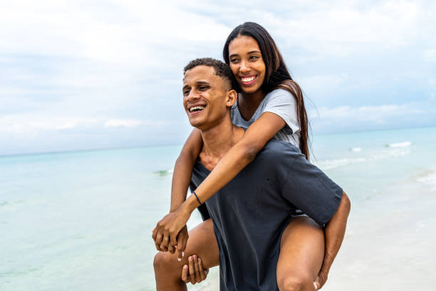 istock Young couple doing piggyback by the ocean 1498236730