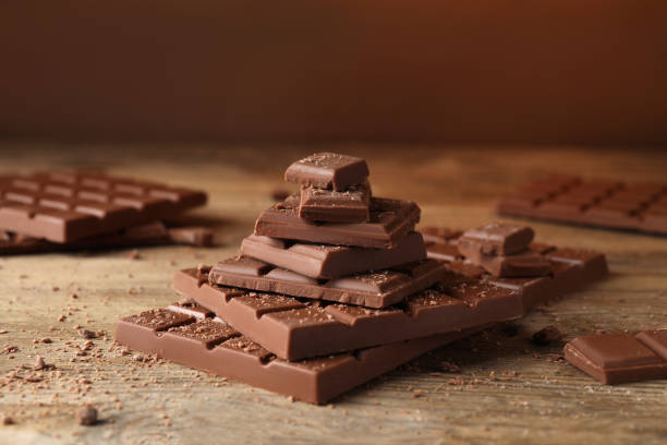 pieces and crumbs of tasty chocolate on wooden table - treated wood imagens e fotografias de stock