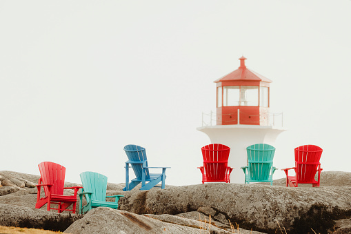 Wooden chairs by the lighthouse at Peggy's Cove  along the coast of Nova Scotia, Canada. Shot with a Canon 5D Mark IV.
