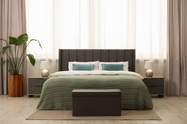 istock Comfortable bed, bedside tables and ottoman in bedroom 1498240287