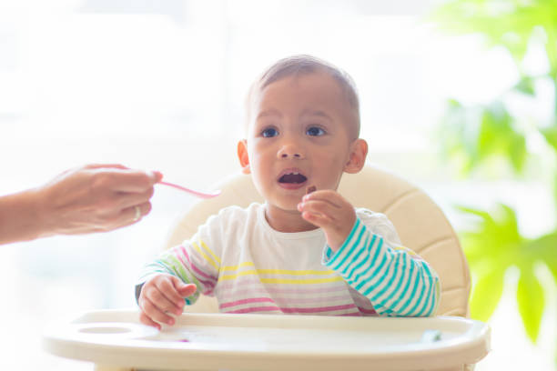 istock Baby eating solid foods in high chair. 1498244907