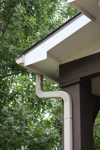 A rain roof gutter system with a pipe for carrying rainwater called a downspout, waterspout, downpipe, drain spout, or roof drain pipe.