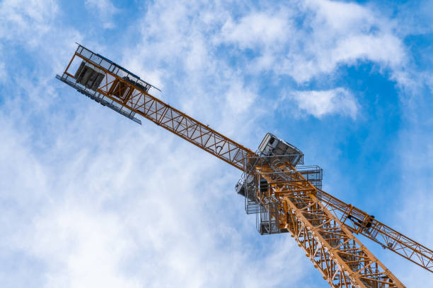 Yellow tower crane against blue sky.