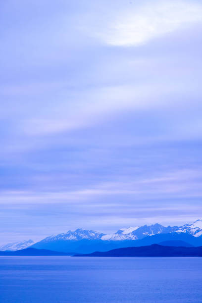 Snow capped mountains and coastal Alaska under pastel sunset