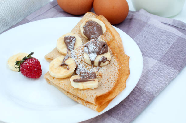 istock Pancakes with strawberries and ingredients for cooking. 1498255076