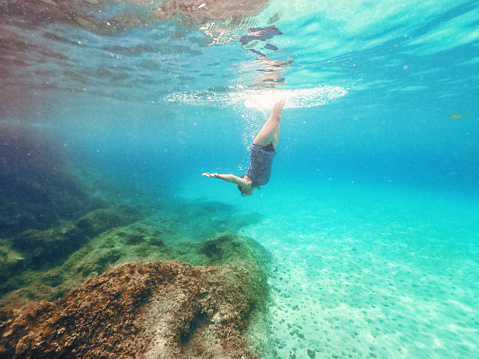 Underwater shoot of a teenage girl snorkeling in crystal blue sea on a Greek island