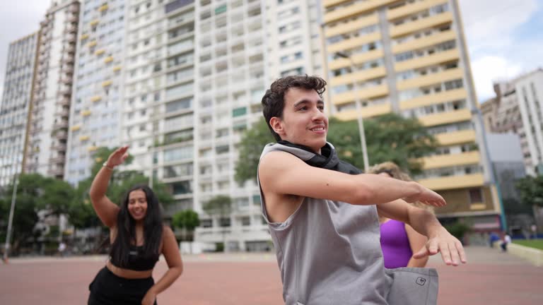 Young man dancing with friends outdoors