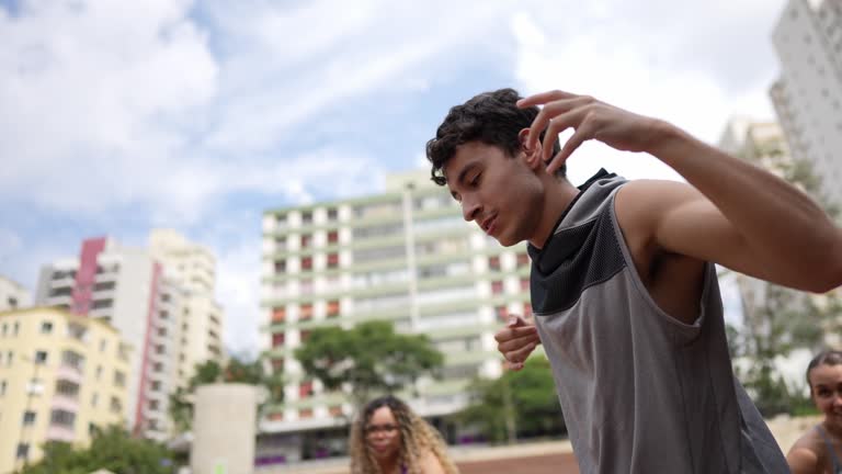 Young man dancing with friends outdoors