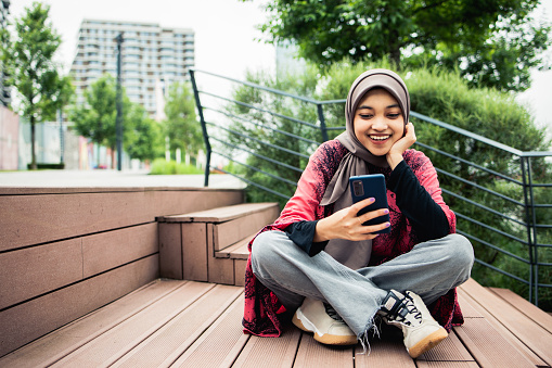 Happy young woman using a smartphone outdoors