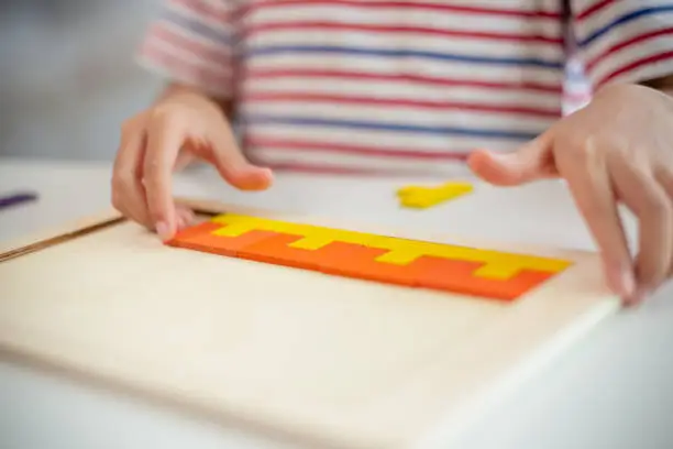 Photo of Asian girls play with puzzles, learn math, education concept