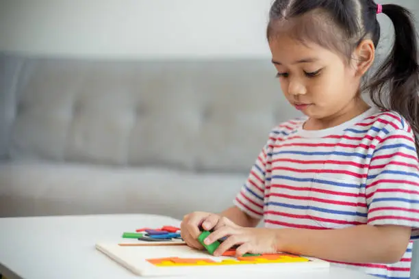 Photo of Asian girls play with puzzles, learn math, education concept