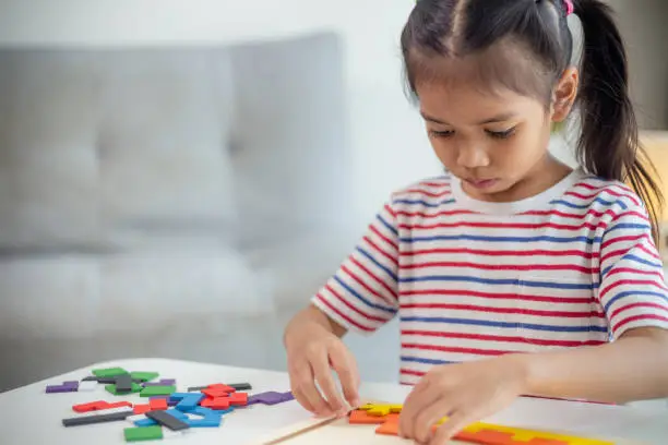 Photo of Asian girls play with puzzles, learn math, education concept