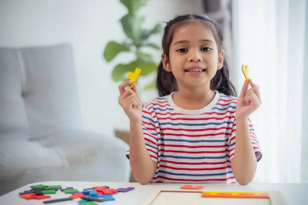 Photo of Asian girls play with puzzles, learn math, education concept