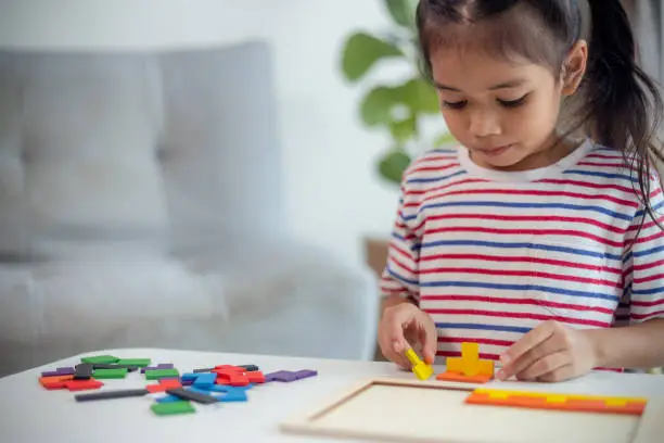 Photo of Asian girls play with puzzles, learn math, education concept