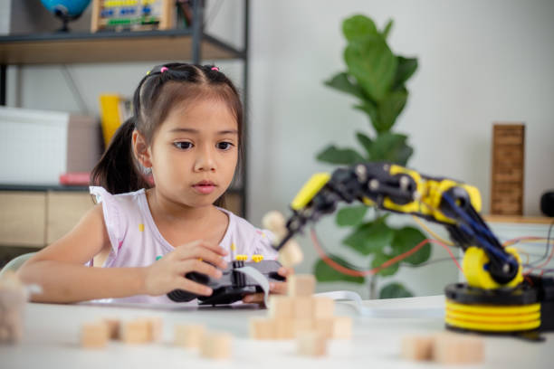 istock STEM education concept. Asian students learn at home by coding robot arms in STEM, mathematics engineering science technology computer code in robotics for kids' concepts 1498270510