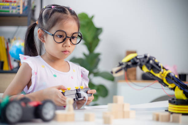 istock STEM education concept. Asian students learn at home by coding robot arms in STEM, mathematics engineering science technology computer code in robotics for kids' concepts 1498270513